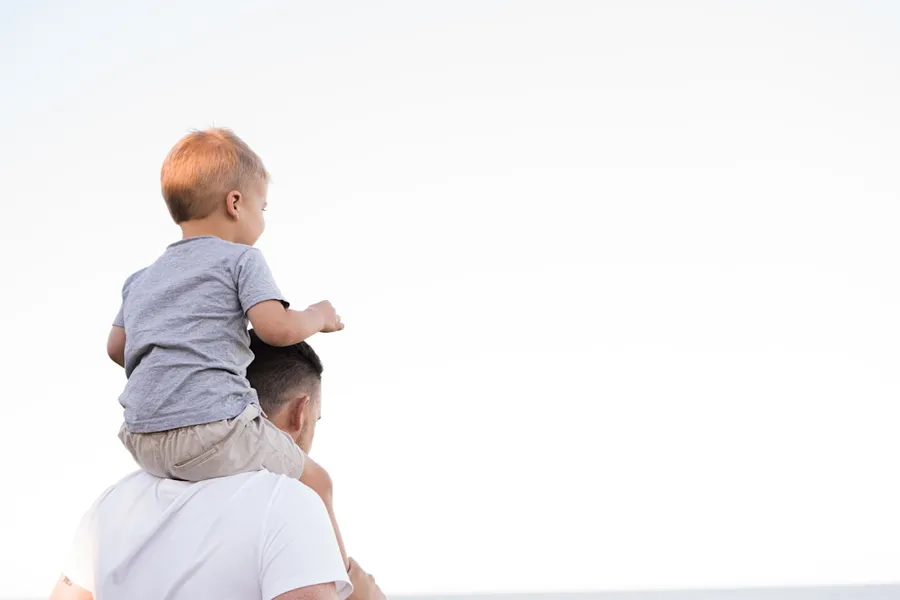 Ilustrasi mimpi ayah angkat — man in white shirt carrying boy