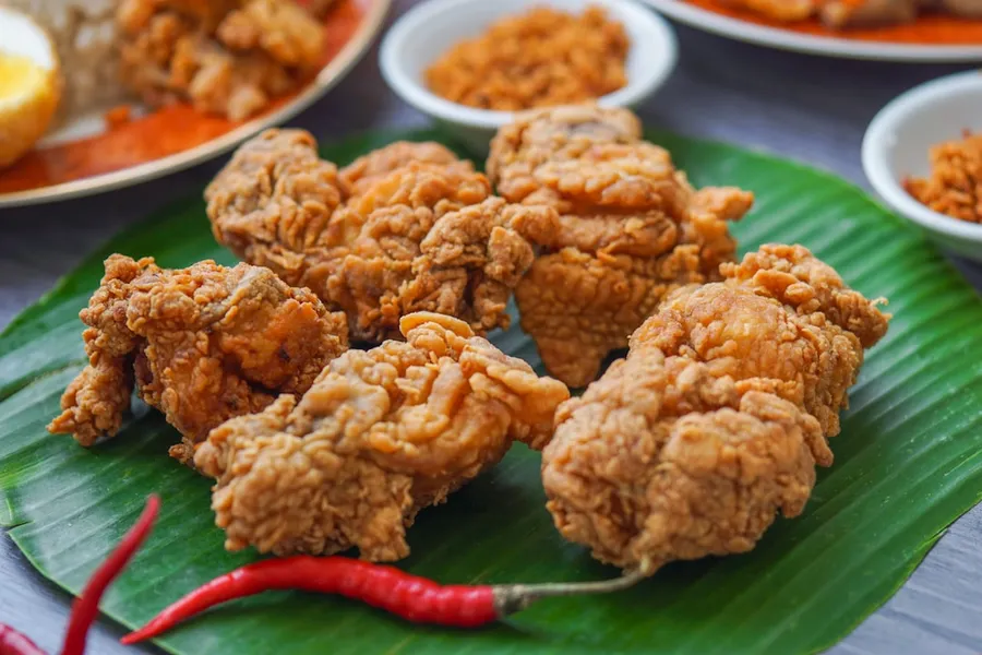 Ilustrasi mimpi ayam goreng — food lot on a green leaf plate