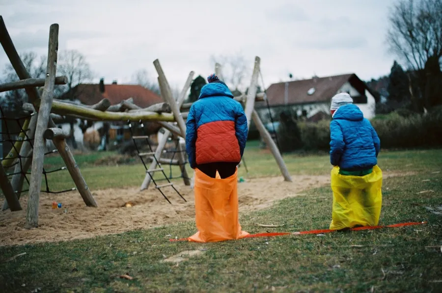 Ilustrasi mimpi balap karung — man in blue and orange jacket standing on green grass field during daytime