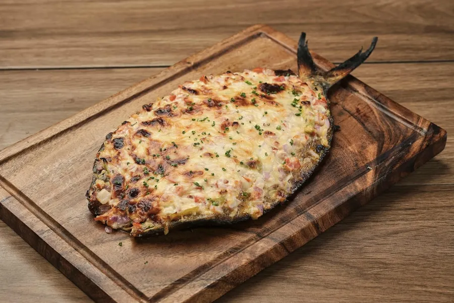 Ilustrasi mimpi bandeng — A pizza sitting on top of a wooden cutting board