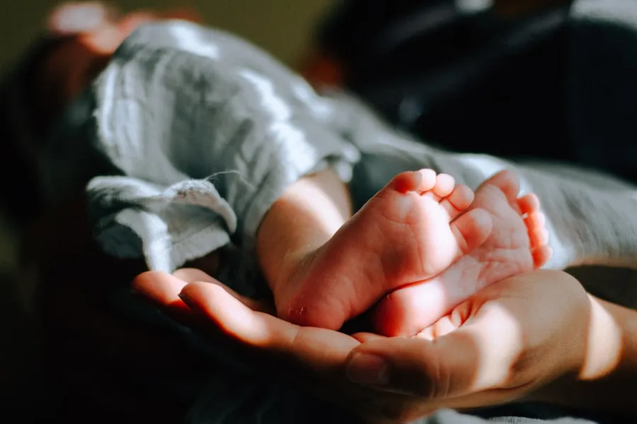 Ilustrasi mimpi bayi — person holding baby feet