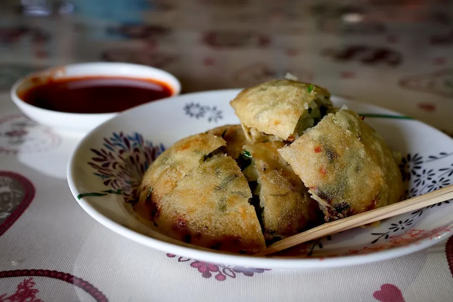 Ilustrasi mimpi bengkuang — a bowl of food with chopsticks on a table