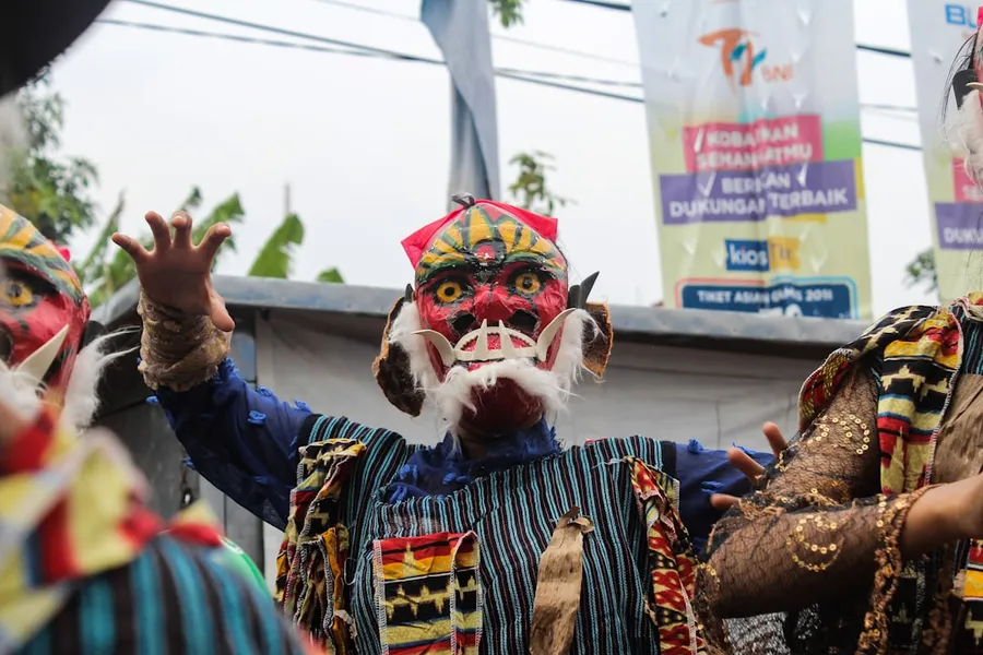 Ilustrasi mimpi betara brahma — unknown person wearing red mask dancing outdoors
