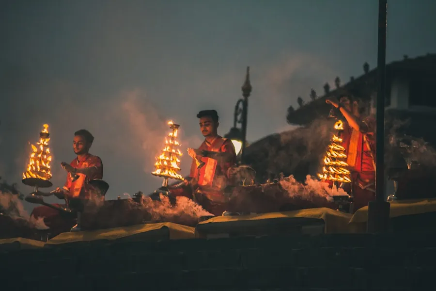 Ilustrasi mimpi betara kala — people sitting on brown wooden bench during night time