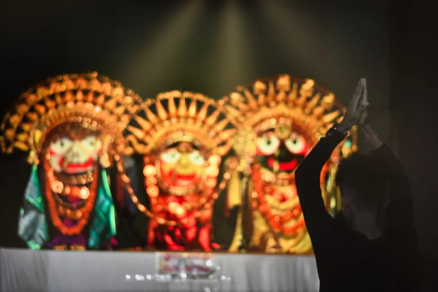 Ilustrasi mimpi buto terong — a person standing in front of a stage with masks on it