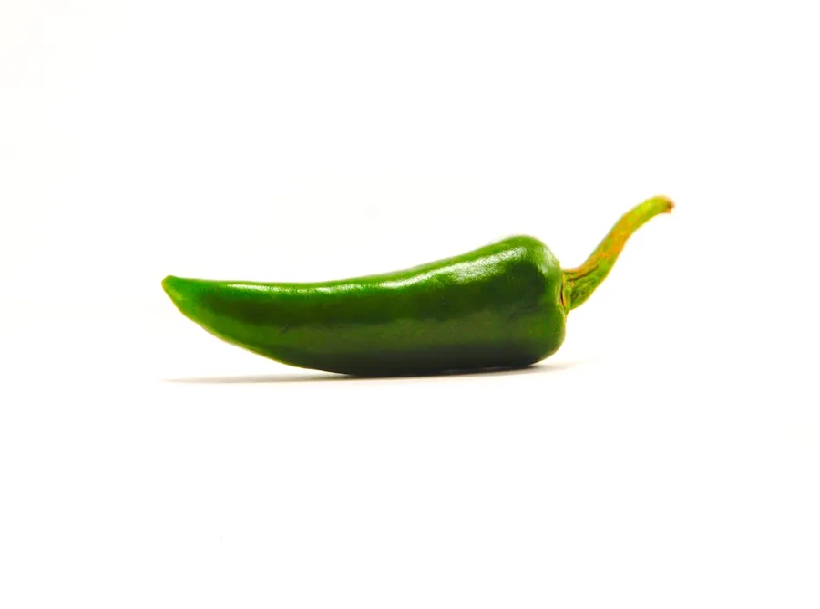 Ilustrasi mimpi cabe — green chili on white surface