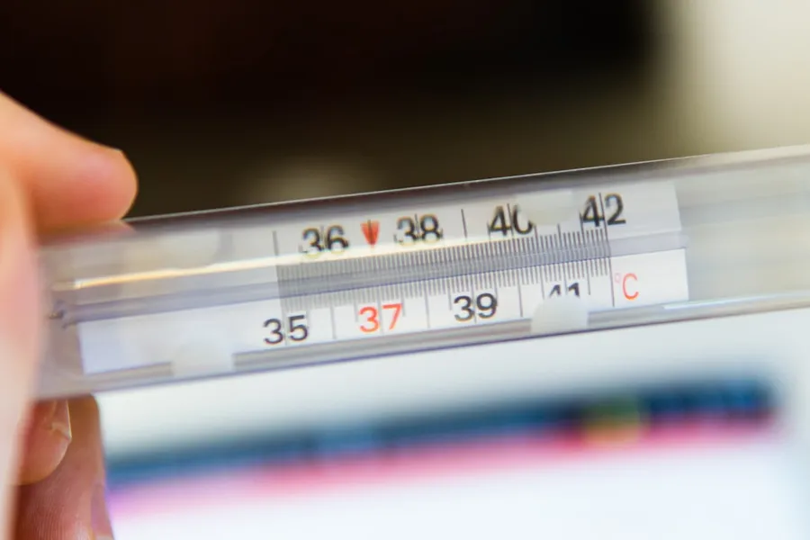 Ilustrasi mimpi demam tinggi — white thermometer at 36 degrees celsius