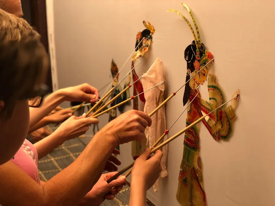 Ilustrasi mimpi dewi kunti — a group of people holding up sticks to a wall