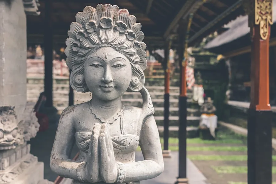Ilustrasi mimpi dewi ratih — woman statue beside of sidewalk during daytime