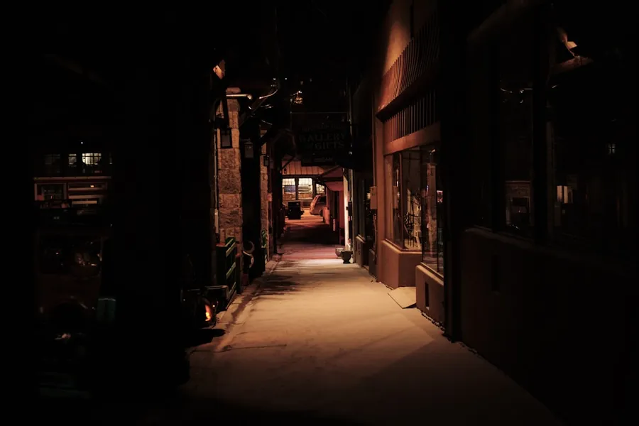 Ilustrasi mimpi dikejar maling — empty street between buildings during daytime