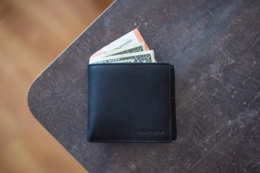 Ilustrasi mimpi dompet — black leather wallet
