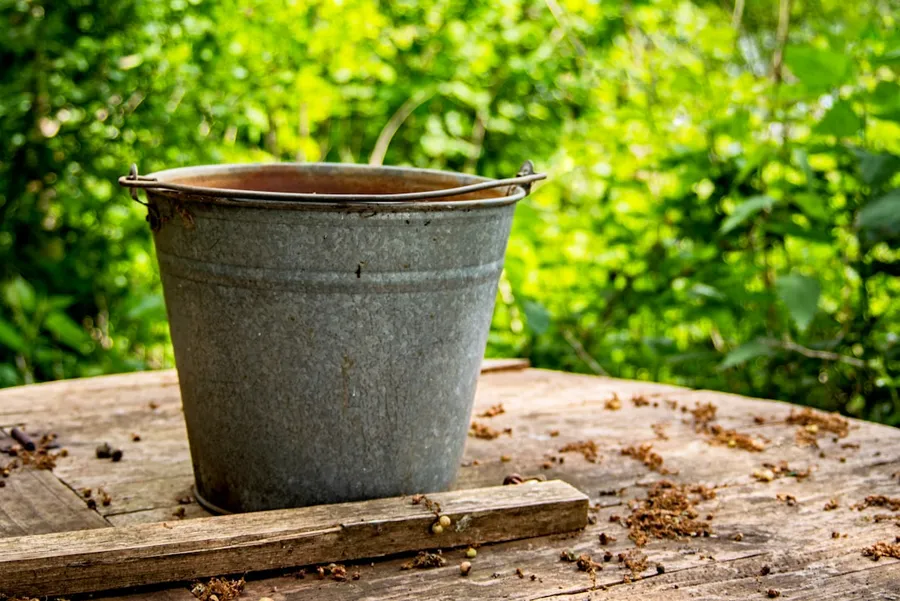 Ilustrasi mimpi ember — gray steel bucket on brown wooden table