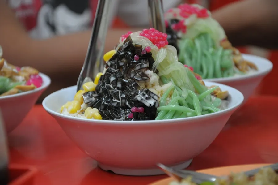 Ilustrasi mimpi es campur — A table topped with three bowls filled with food