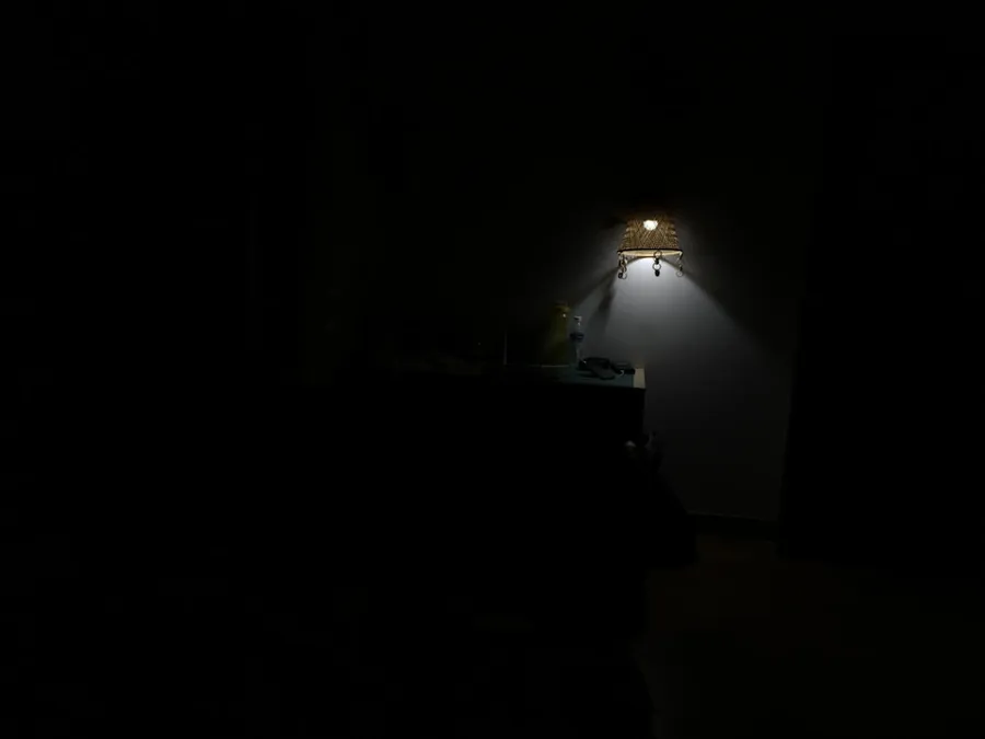 Ilustrasi mimpi fobia — a dark room with a lamp on the wall