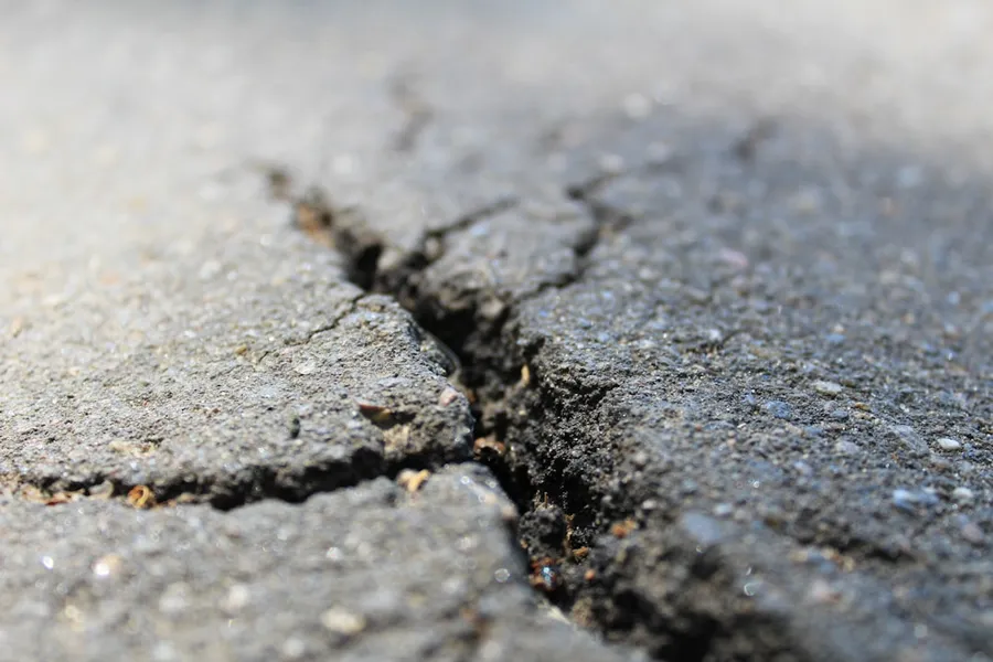 Ilustrasi mimpi gempa bumi — a crack in the asphalt of a road