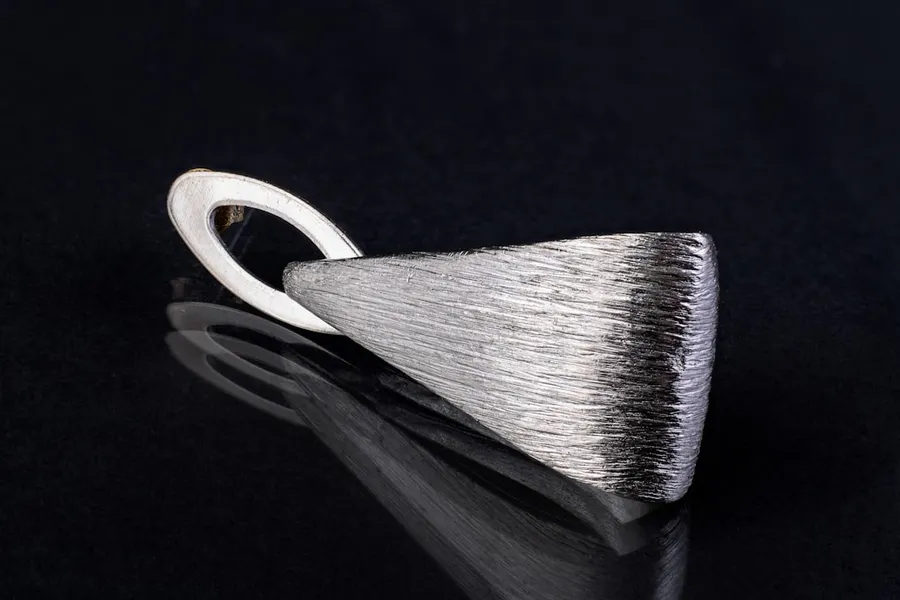 Ilustrasi mimpi gigi perak — a close up of a metal object on a black surface