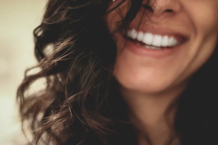 Ilustrasi mimpi gigi — long black haired woman smiling close-up photography