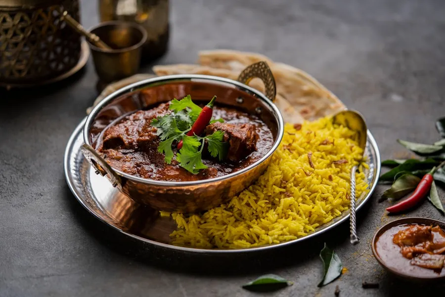 Ilustrasi mimpi gulai kambing — a plate of food on a table