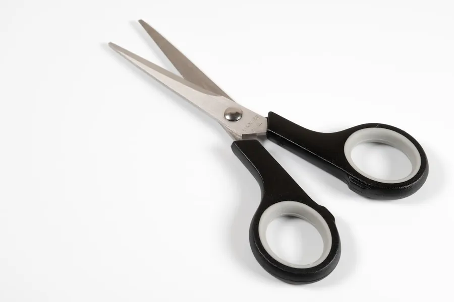 Ilustrasi mimpi gunting — a pair of scissors sitting on top of a white table