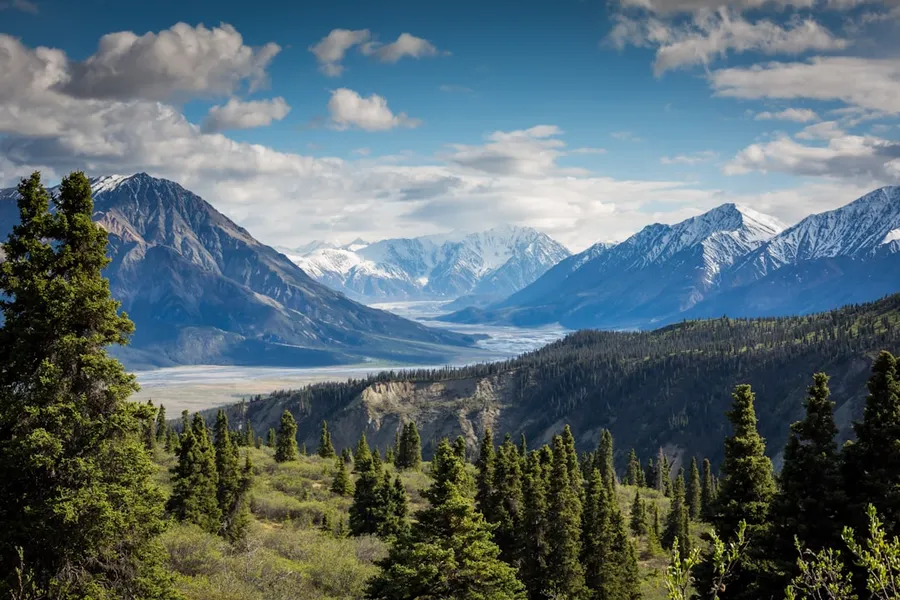Ilustrasi mimpi gunung — snow capped mountains with valley and forest