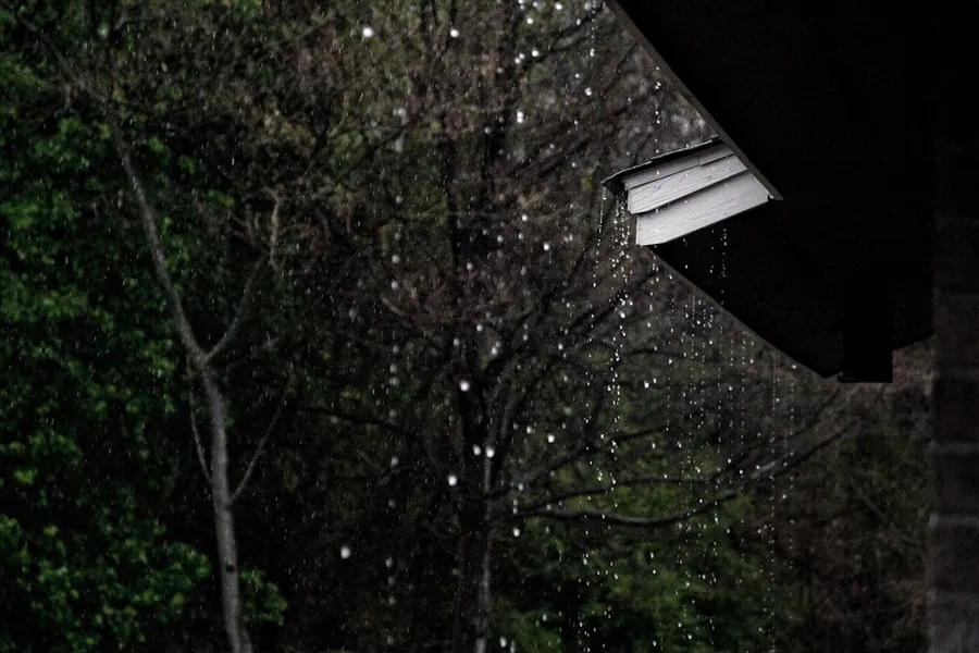 Ilustrasi mimpi hujan lebat — rain dropping from roof