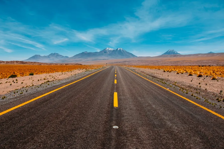 Ilustrasi mimpi jalan raya — lone road going to mountains