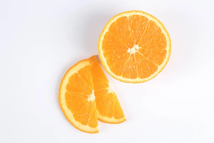 Ilustrasi mimpi jeruk manis — sliced orange fruit on white surface