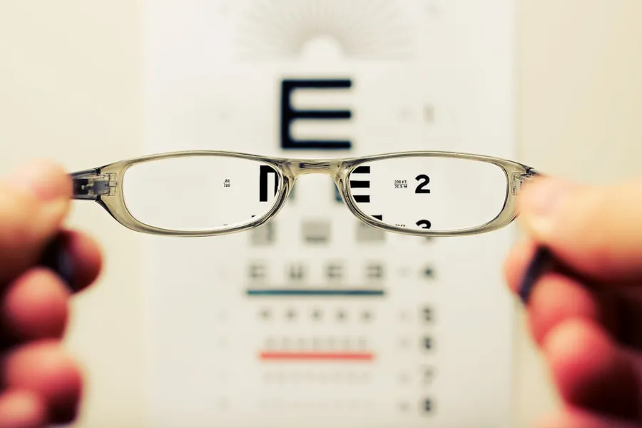 Ilustrasi mimpi kaca mata — person holding eyeglasses