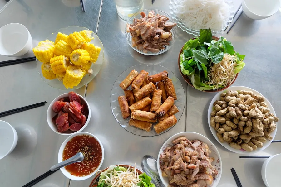 Ilustrasi mimpi kacang tanah — A table filled with various vietnamese dishes and ingredients.