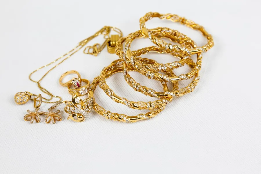 Ilustrasi mimpi kalung mas — gold chain necklace on white surface