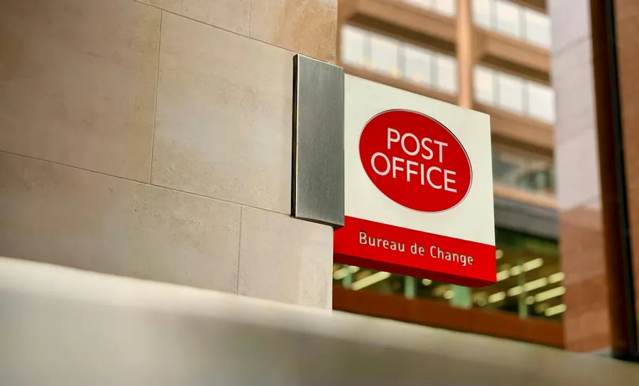 Ilustrasi mimpi kantor pos — a post office sign on the side of a building