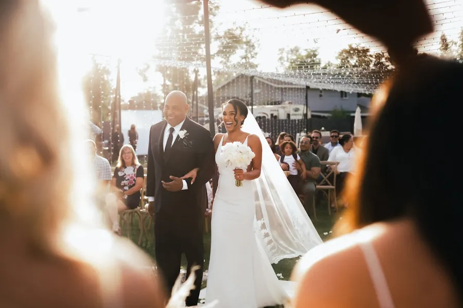 Ilustrasi mimpi kawin massal — bride and groom standing on the street during daytime