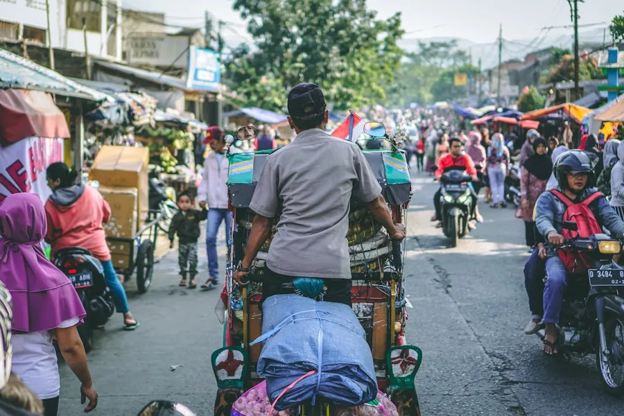 Ilustrasi mimpi ke pasar — selective photography of man pedaling wagon