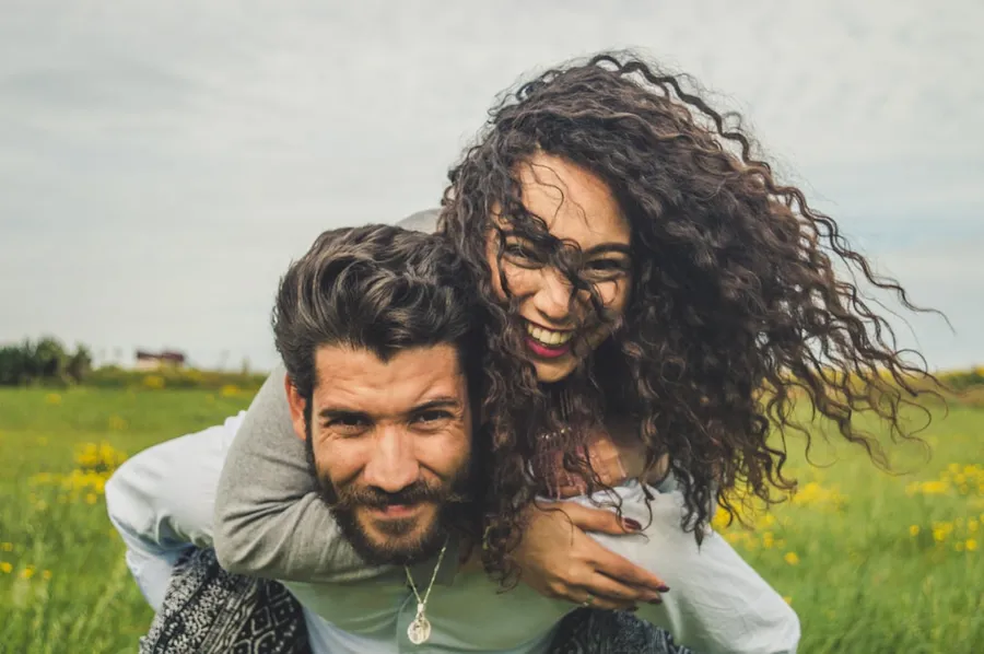 Ilustrasi mimpi kekasih — woman riding on man's back on green field