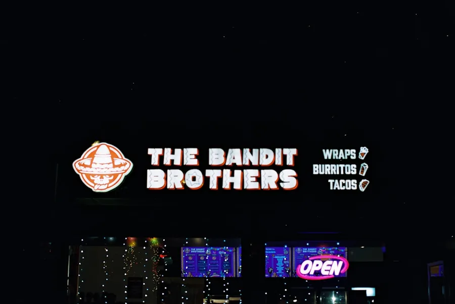 Ilustrasi mimpi kepala rampok — The bandit brothers restaurant sign at night.