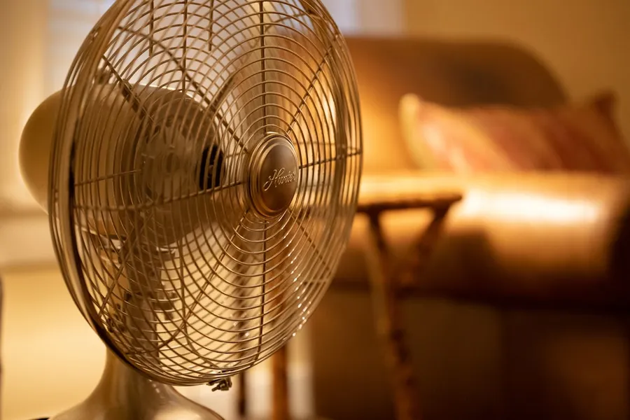Ilustrasi mimpi kipas — white stand fan turned on in room