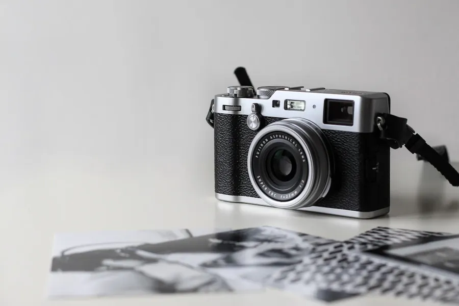 Ilustrasi mimpi kodak — black and gray film camera near printed photos