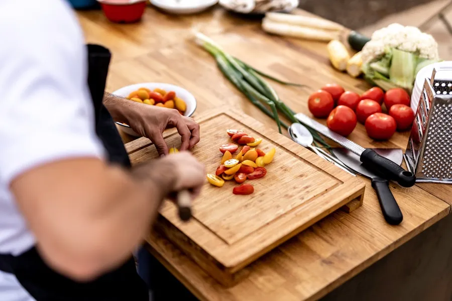 Ilustrasi mimpi koki — a person cutting up vegetables on a cutting board