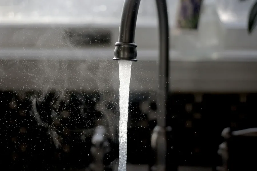 Ilustrasi mimpi kran air — a faucet running water from a kitchen sink