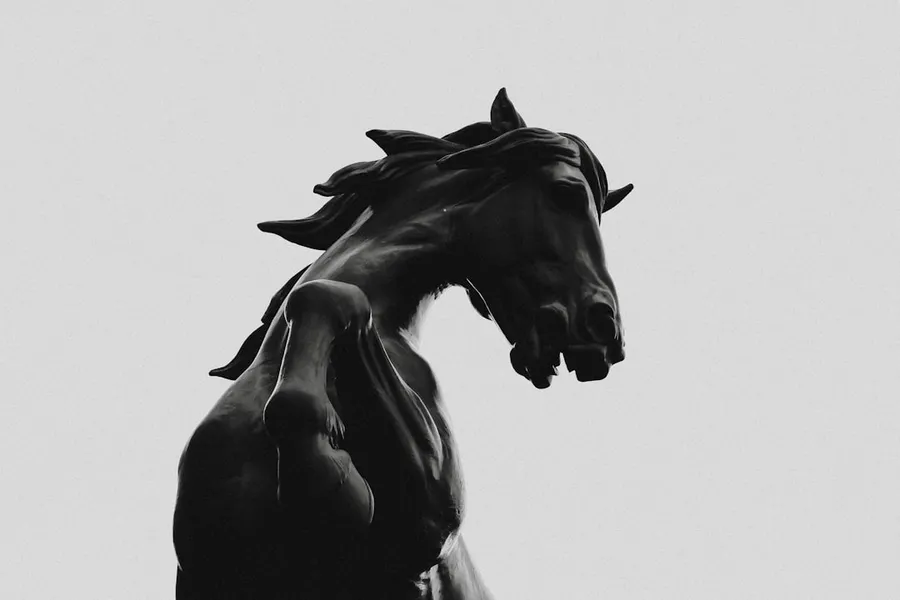 Ilustrasi mimpi kuda hitam — black horse statue in grayscale photography