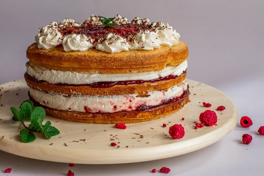 Ilustrasi mimpi kue bolu — white and brown cake on white ceramic plate