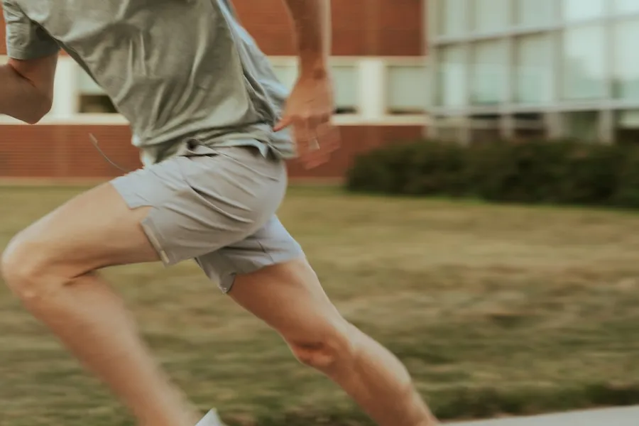 Ilustrasi mimpi lari cepat — a man in shorts and a t - shirt is playing with a frisbee