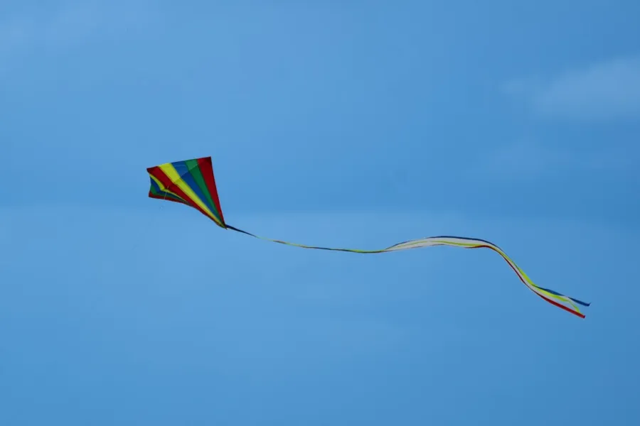 Ilustrasi mimpi layang-layang — a kite flying in the sky