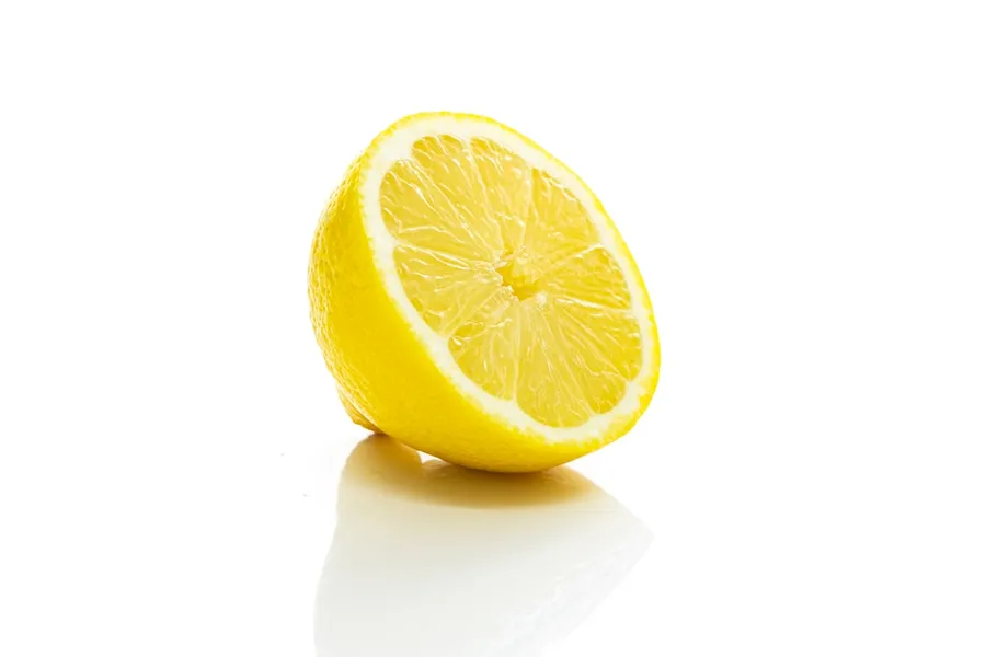 Ilustrasi mimpi lemon — yellow lemon fruit on white surface