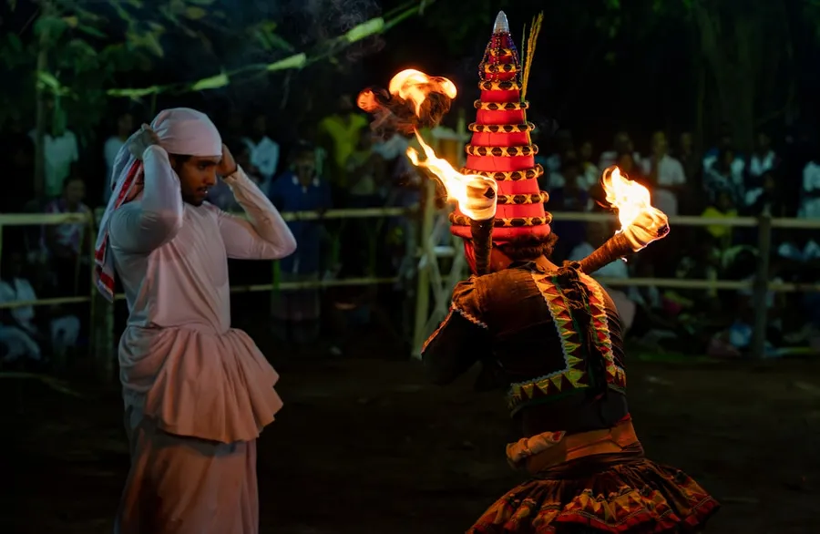 Ilustrasi mimpi lesmana widakta — Traditional fire dance performance with two people at night.