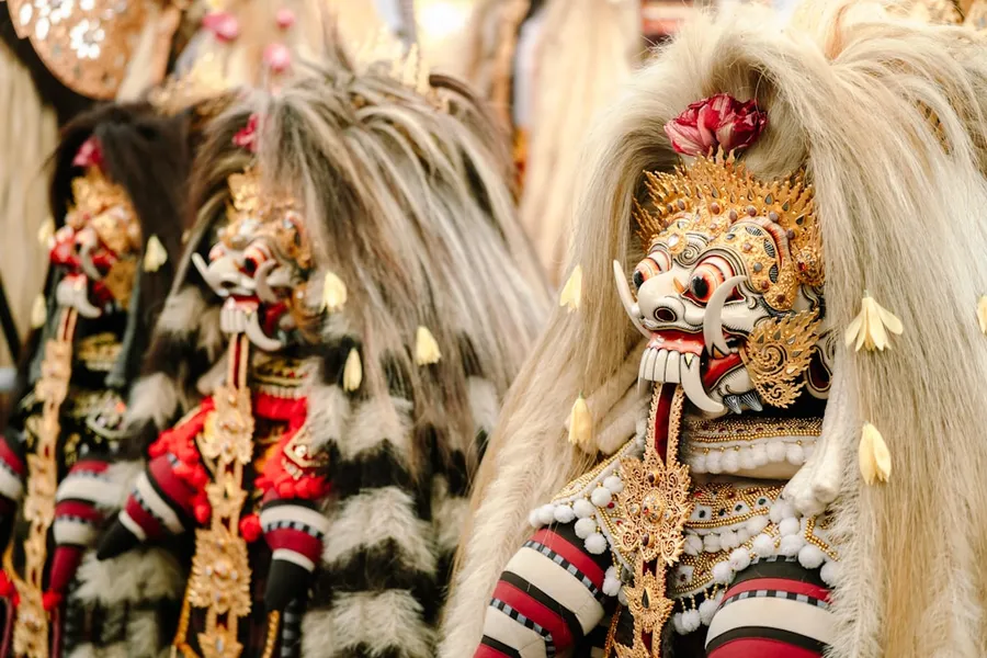 Ilustrasi mimpi lesmanawati — Two ornate balinese barong masks with elaborate headdresses