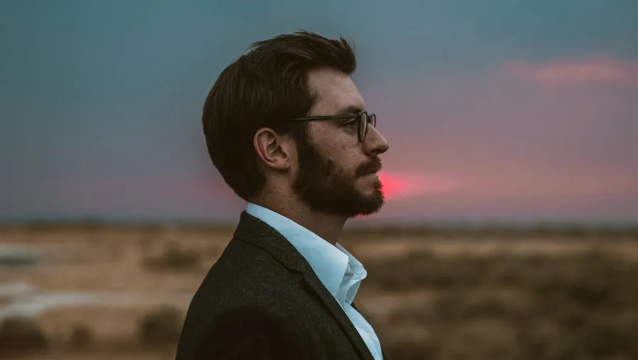 Ilustrasi mimpi mata keranjang — man in black formal suit wearing eyeglasses