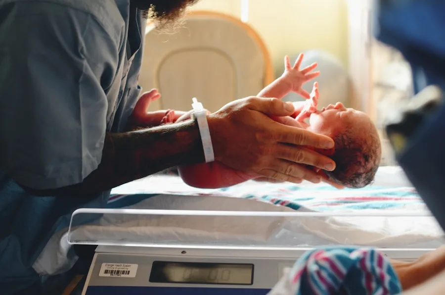Ilustrasi mimpi melahirkan — person wearing gray shirt putting baby on scale