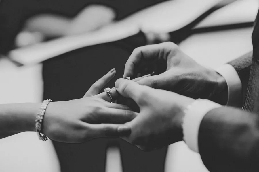 Ilustrasi mimpi memakai cincin — grayscale photo of person wearing ring