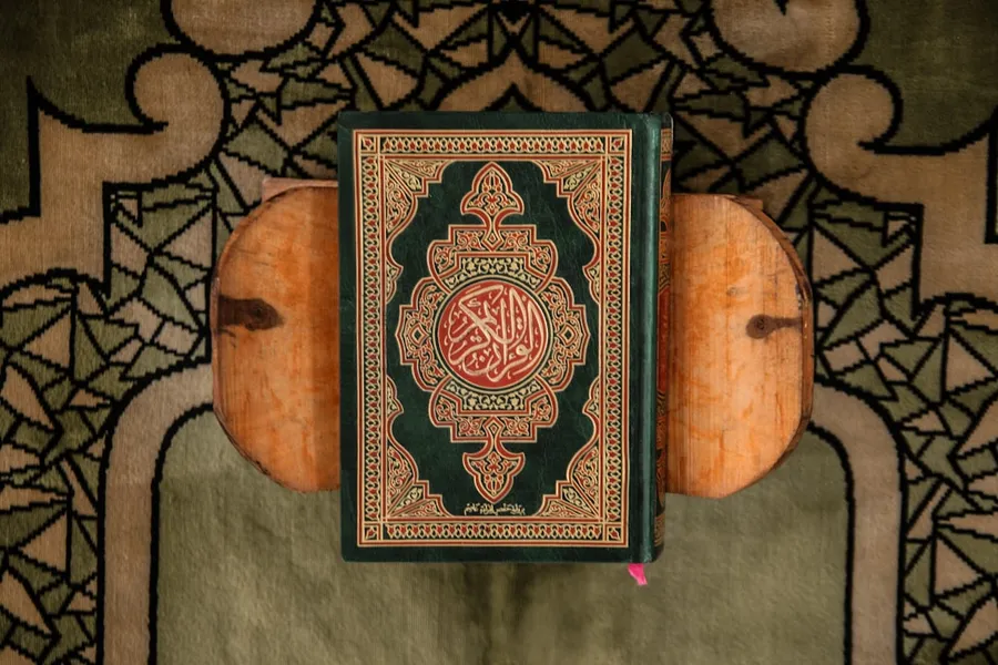 Ilustrasi mimpi membaca al quran — black and brown book on gray textile